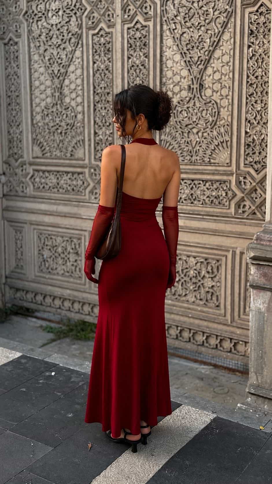 Female model wearing the Bordo Imperia maxi dress with matching gloves in an outdoor setting