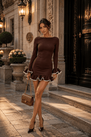 Female model wearing a brown mini dress with white ruffle trim and flared cuffs