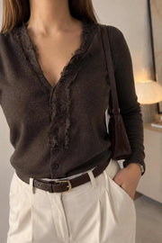 Close-up of a brown lace-trim button cardigan styled with cream tailored trousers