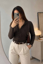 Female model wearing a brown lace-trim cardigan with cream high-waisted trousers