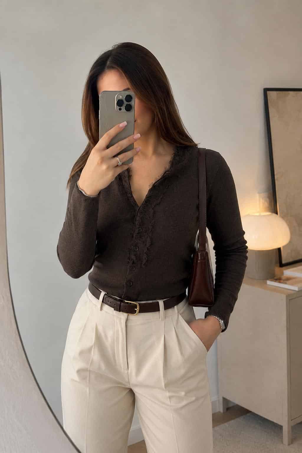 Female model wearing a brown lace-trim cardigan with cream high-waisted trousers