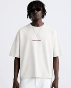 Male model wearing the white CONFIDENT oversized T-shirt with white trousers
