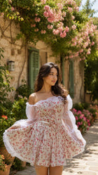 Female model wearing a white Floral Mini Dress with red floral print and sheer off-shoulder sleeves