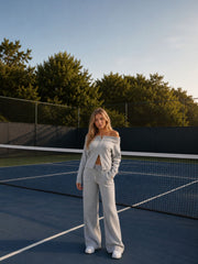 Female model wearing the Grey Off-Shoulder Knit Set on a tennis court