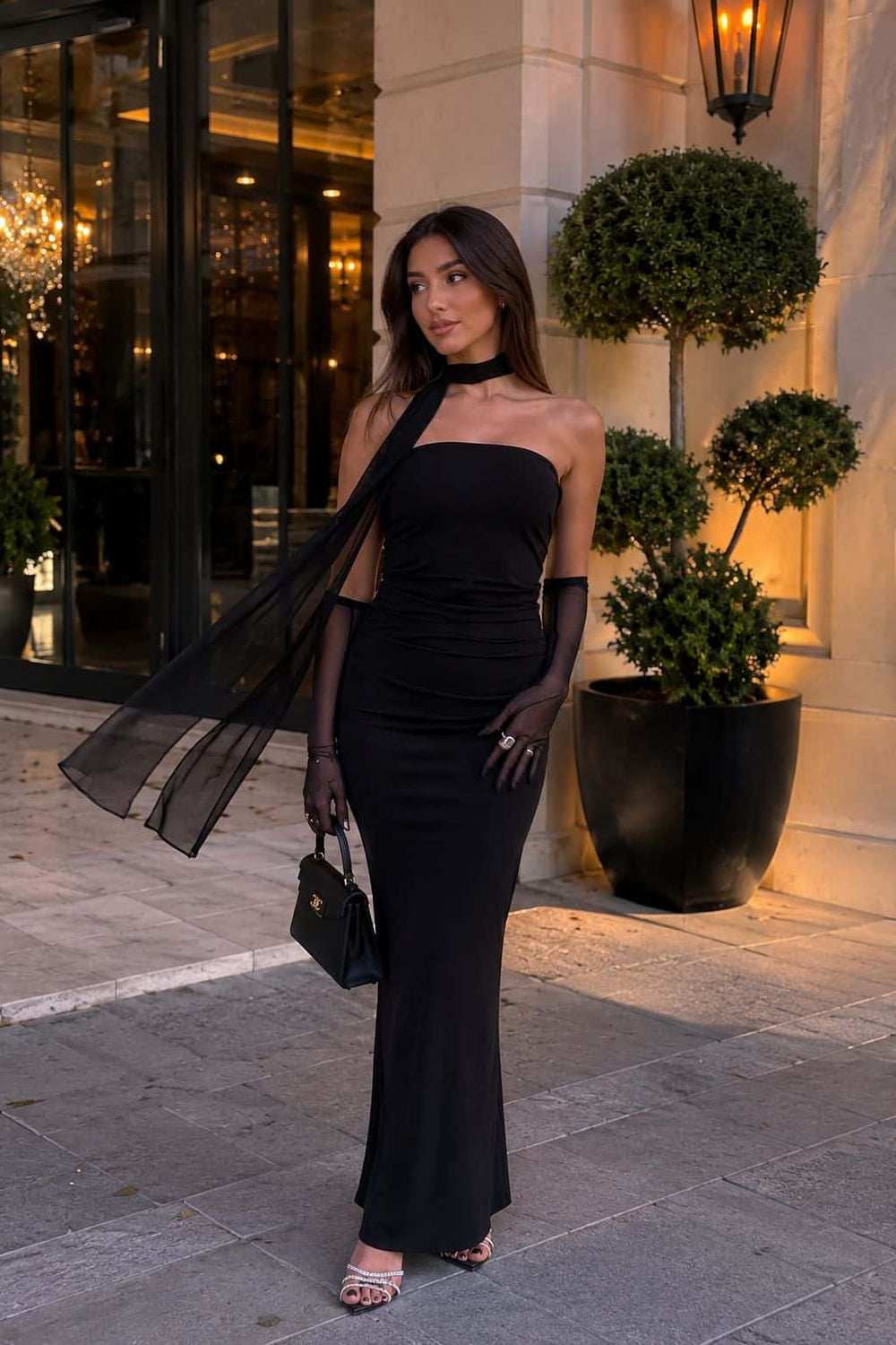 Female model wearing the black Nocturne Dress with sheer gloves and a flowing scarf
