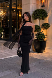 Female model wearing the black Nocturne Dress with sheer gloves and a flowing scarf