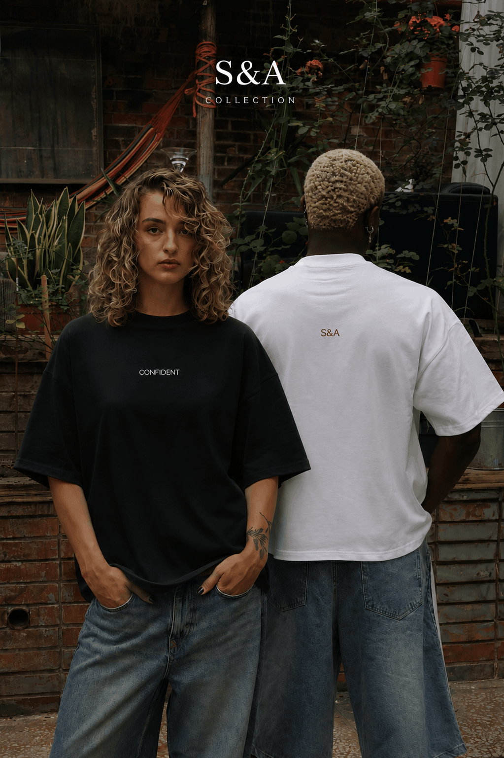 Female and male models wearing black and white S&A Collection oversized T-shirts