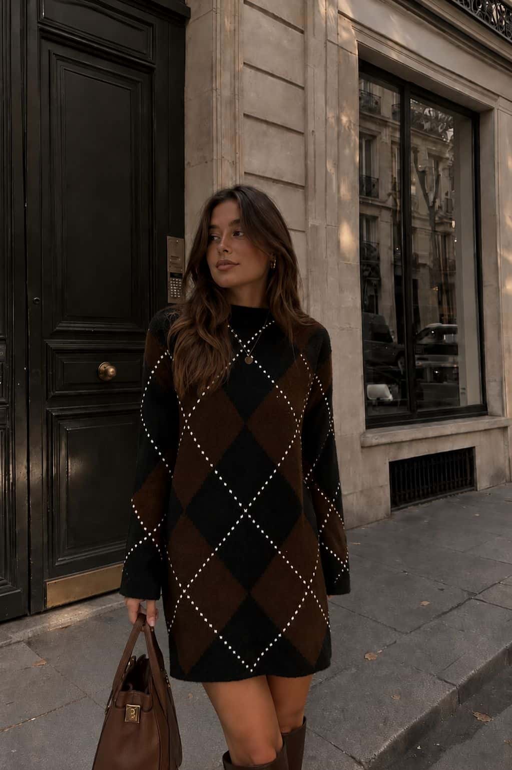 Female model wearing a brown and black argyle Sweater Dress with knee-high boots
