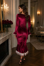 Back view of a female model wearing a burgundy Velvet Midi Dress with a fitted silhouette and ruffle hem